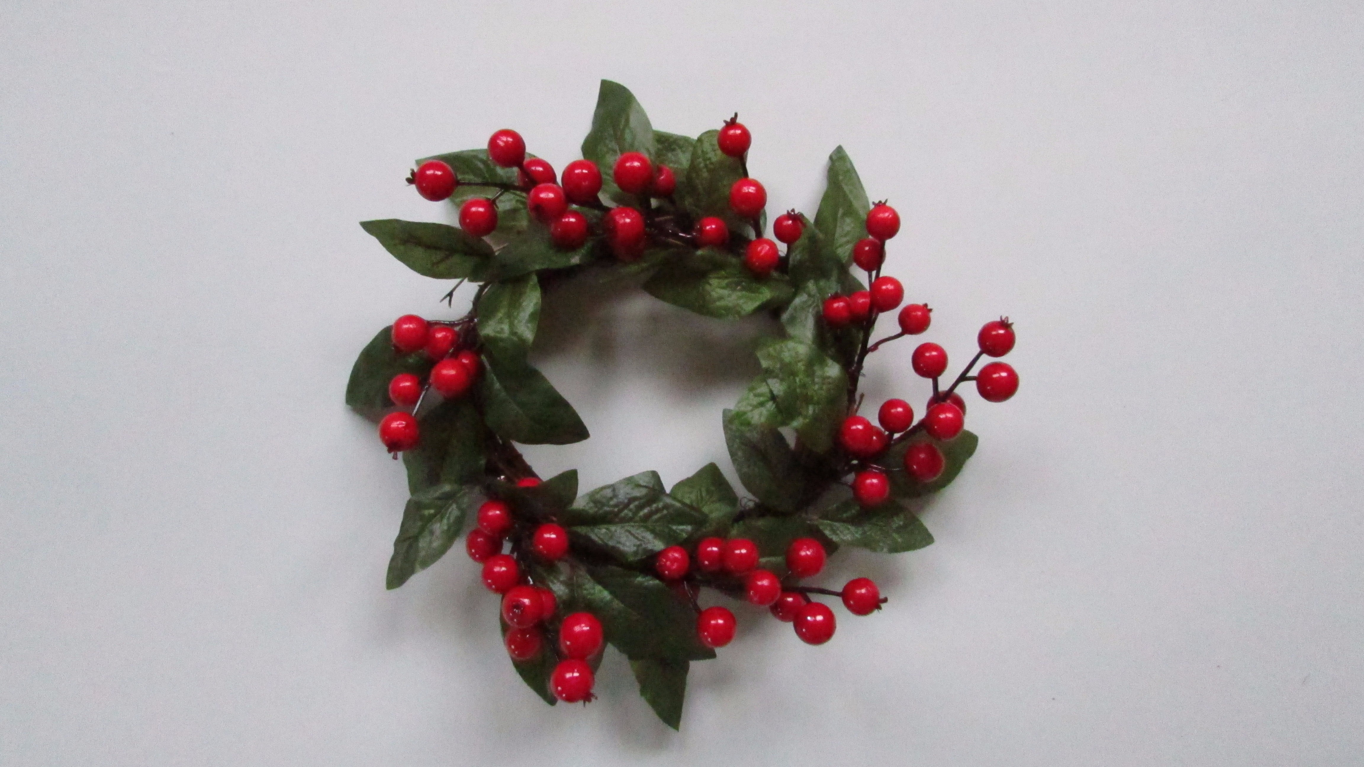 Christmas candle ring with green leaves and red berries