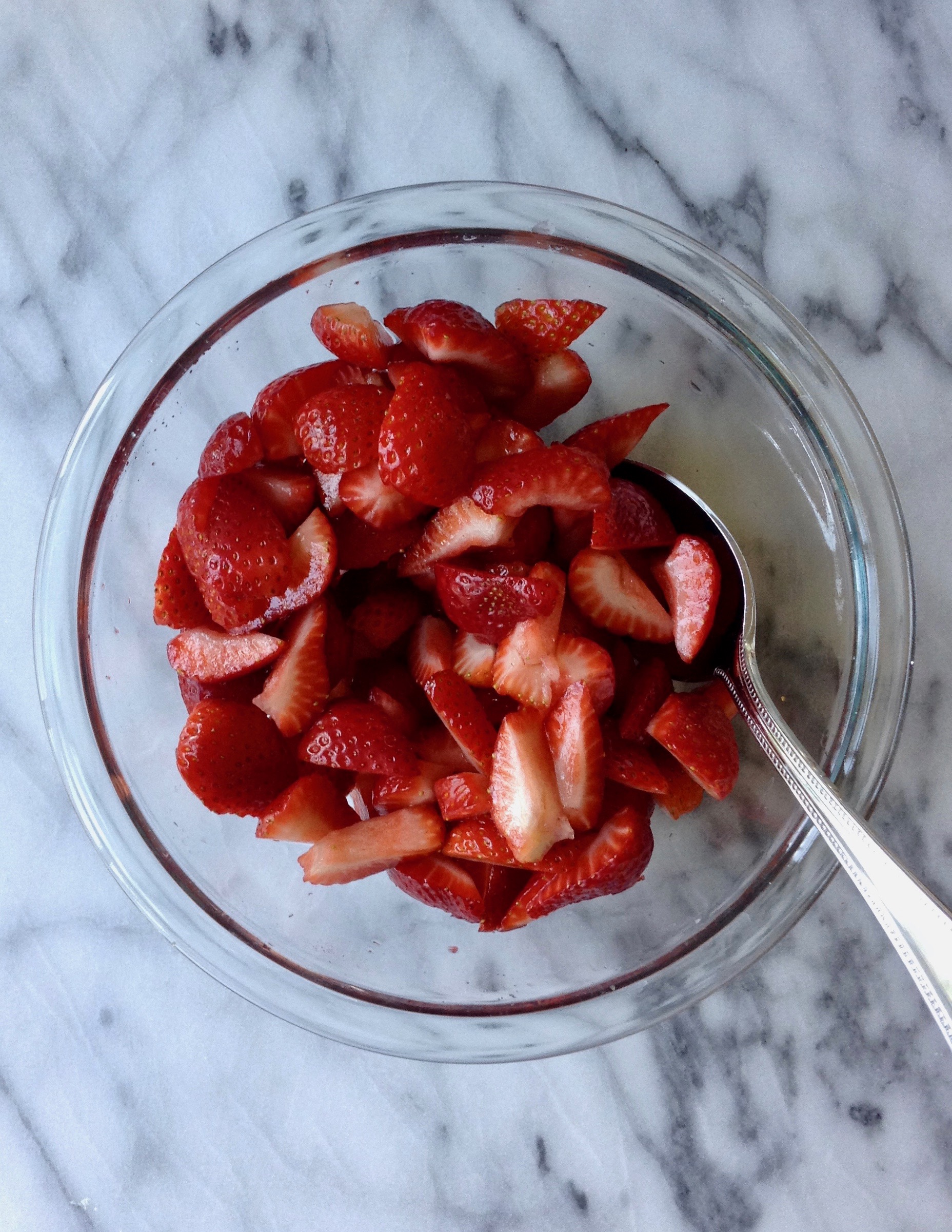 sliced, syrupy strawberries in a bowl