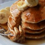 stack of banana pancakes with maple syrup