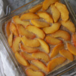 baked oatmeal topped with peaches in baking dish
