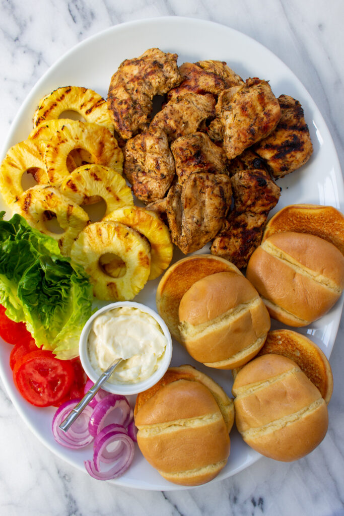jerk chicken burger ingredients on a platter